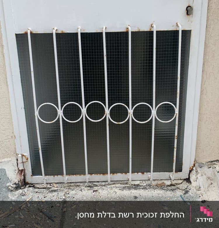 זכוכית מחוספסת מאחורי סורגי מתכת לבנים